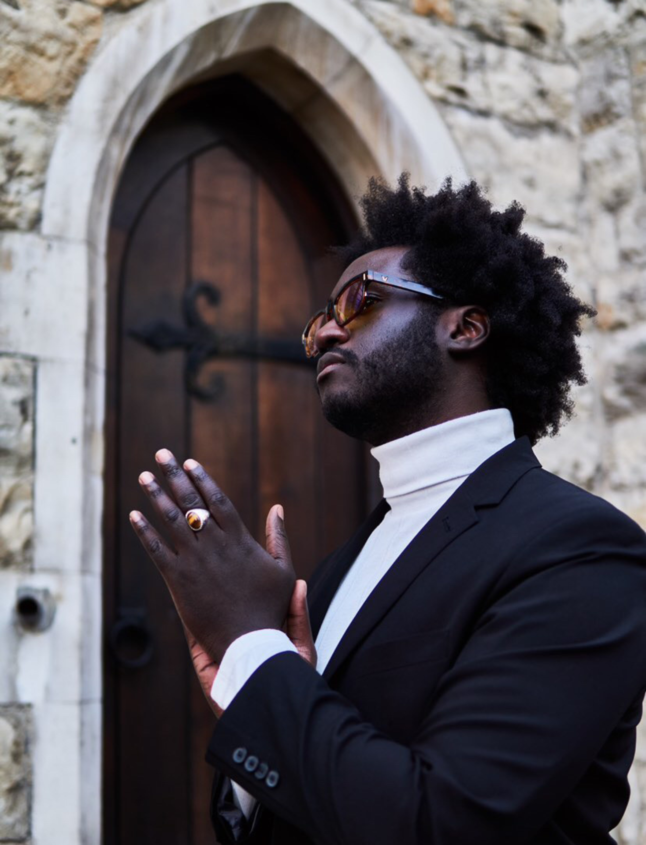 Ian McClue money rub hands whilst wearing a white turtle neck